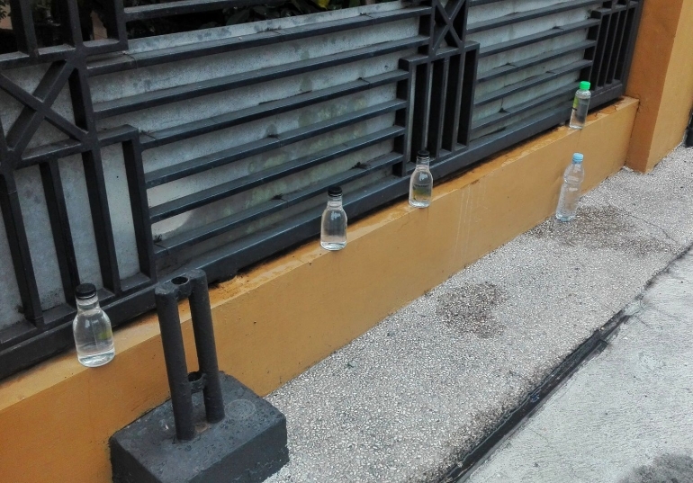 Menaruh botol berisi air di depan pagar dianggap dapat mencegah kucing liar masuk ke rumah (dokpri)