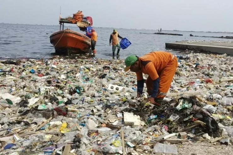Petugas SDA Kep Seribu mengangkut sampah-sampah yang terbawa arus angin barat di pantai KBN Cilincing, Jakarta Utara (Dok. SDA Kep Seribu via megapolitan.kompas.com) 