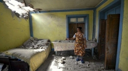 Seorang wanita menunjukkan kerusakan pada rumahnya setelah penembakan oleh pasukan Armenia di wilayah Tovuz Azerbaijan, Selasa, 14 Juli 2020. Sumber: Foto AP / Ramil Zeynalov dalam laman Tirto.id