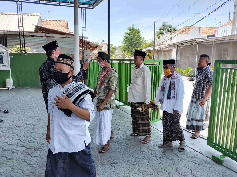 Remaja masjid sedang mengecek suhu para jamaah sholat Jumat. Dokpri