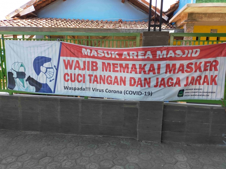 Poster terpampang di depan pintu masuk masjid.