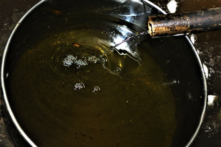 Minyak serai wangi hasil destilasi mengalir ke wadah penampungan (Marahalim Siagian)