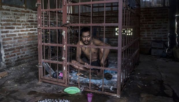 Suhananto (30 tahun), penderita gangguan mental di dalam kurungan di kecamatan Jambon, Ponorogo, Jawa Timur.  Ulet Ifansasti/Getty Images (Tempo.co)