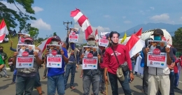 Ratusan warga Ciletuh Hilir mengarak poster bergambar Donald Trump di pintu gerbang kawasan Trump Development dan MNC Lido City di jalan raya Bogor-Sukabumi, Jawa Barat, berdekatan dengan Danau Lido, pada Kamis (01/10/2020) lalu. Foto: isson khairul 