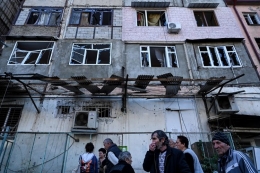 Orang-orang berkumpul di depan sebuah gedung apartemen yang diduga rusak oleh penembakan baru-baru ini di kota utama Stepanakert di wilayah Nagorno-Karabakh pada 3 Oktober 2020, selama pertempuran yang sedang berlangsung antara Armenia dan Azerbaijan atas wilayah yang disengketakan.(AFP via Kompas.com)