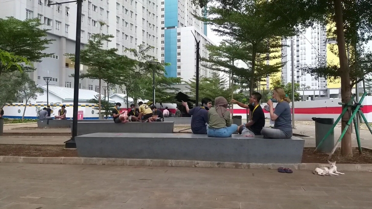 Suasana di taman samping tower 2 RSDC Wisma Atlet. Sebagian relawan menggunakan waktu istirahat mereka dengan duduk-duduk santai di taman ini sembari berinteraksi dengan sesama. Ini bagian dari upaya merawat spirit kerja serta bersama menjaga agar tetap gembira untuk menaikkan imunitas tubuh. Foto: isson khairul