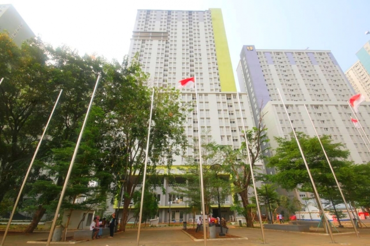 Sisi lain taman samping tower 2 RSDC Wisma Atlet. Pepohonan yang hijau, ruang yang lapang untuk berolahraga, bangku-bangku beton untuk berinteraksi, serta kibaran merah putih. Semua itu menumbuhkan harapan, membangkitkan kegembiraan, serta menaikkan imunitas tubuh. Suasana lingkungan RSDC Wisma Atlet ini turut mempercepat pemulihan pasien Covid-19. Foto: joko dolok