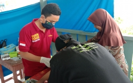 Foto : Dokter Sidiq sedang melakukan proses khitan di wilayah transmigrasi SP 4 (dokpri).