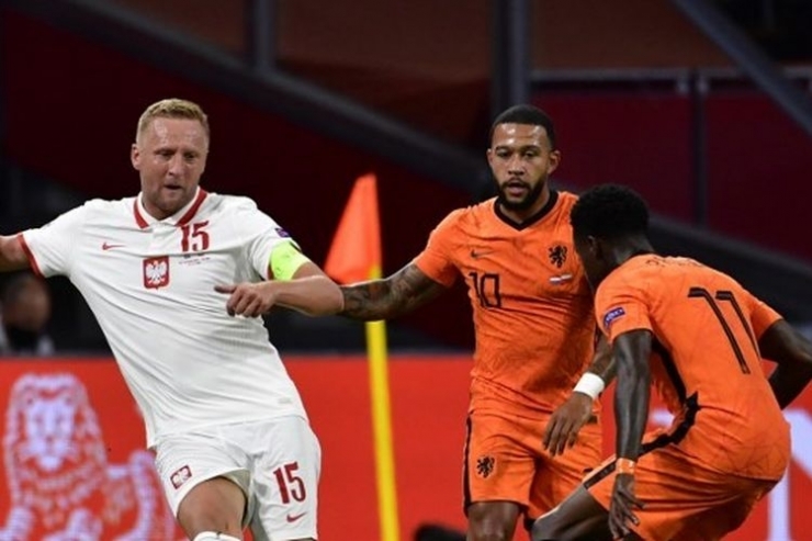 Kamil Glik berduel dengan Memphis Depay dalam laga Belanda vs Polandia pada ajang UEFA Nations League yang berlangsung Sabtu (5/9/2020).| Sumber: AFP/John Thys via Kompas.com