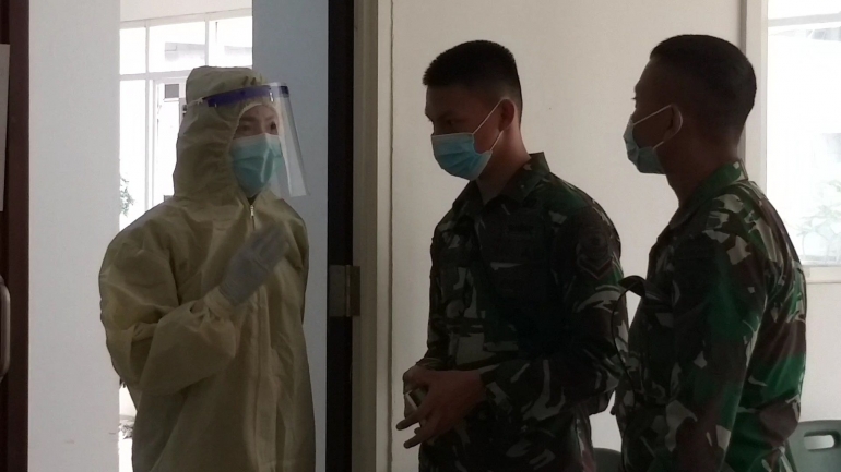 Tenaga kesehatan (nakes) di Rumah Sakit Darurat Covid-19 (RSDC) Wisma Atlet, memberikan penjelasan tentang swab test kepada dua anggota TNI di area screening Covid-19 Lantai 2 Tower 3 Wisma Atlet. Pemahaman tentang swab test ini penting, untuk meningkatkan kesadaran akan perlindungan diri. Foto: isson khairul