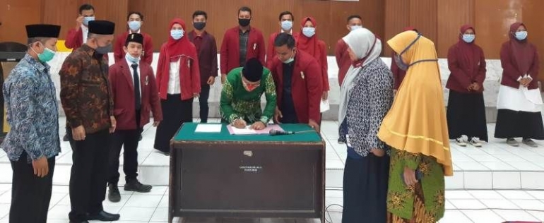 Ketua PD Muhammadiyah Padang Pariaman Fakhri Zaki menandatangani berita acara pelantikan PC IMM Kota Pariaman dan Padang Pariaman. (foto dok imm)