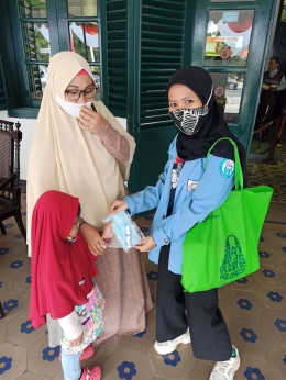 Mahasiswa Regita Yeni Safitri Membagikan Masker kepada pengunjung