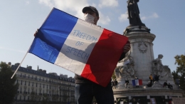 Seorang demonstran memegang bendera Prancis. (firstpost.com)