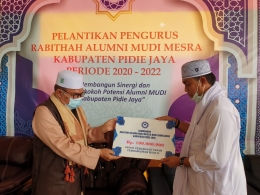 Abiya Kuta Krueng menyerahkan bantuan dari alumni MUDI Samalanga Pidie Jaya sebanyak 100 juta sebagai bantuan untuk pembangunan Dayah MUDI-2 tahap pertama. Sumber foto: Facebook Helmi Abu Bakar