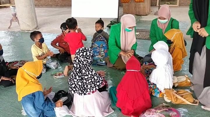potret Kelompok 048 mengajarkan anak-anak di Desa Blang Weu Panjoe cara menggunakan Hand Sanitizer yang benar