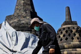Petugas Balai konservasi Candi Borobudur menutup stupa menggunakan terpal (Foto Tubagus Andri Maulana)
