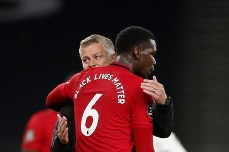 Paul Pogba berpelukan dengan Ole Gunnar Solskjaer usai laga Tottenham Hotspur vs Manchester United pada lanjutan pekan ke-30 Liga Inggris di Tottenham Hotspur Stadium, Sabtu (20/6/2020). (sumber: AFP/GETTY IMAGES/POOL via kompas.com)