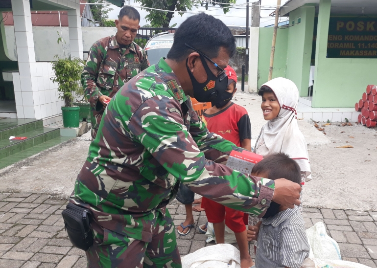 Danramil Mayor Kav Salahuddin Basir memasangkan masker bantuan Presiden RI kepada para pemulung cilik. | dokpri