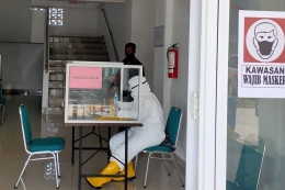 Seorang tenaga kesehatan berjaga di tempat pendaftaran untuk pasien Covid-19 menjalani isolasi mandiri (Tresno Setiadi/KOMPAS)