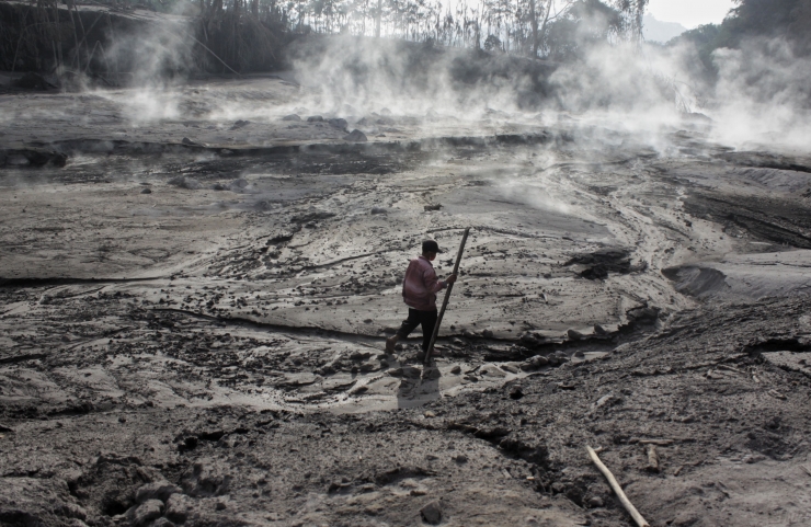 Salah seorang penduduk sedang berjalan menyusuri aliran lava panas/Foto: Tubagus Andri Maulana 