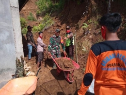 Ketua Kwarcab 0305 Gerakan Pramuka Padang Pariaman Dewiwarman memimpin langsung kegiatan Abdimas yang diikuti 75 anggota di rumah masyarakat yang terkena longsoran tebing akibat hujan berkepanjangan. (foto dok dewiwarman)