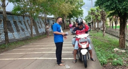 Sekretaris Karang Taruna Desa Karangsegar, membagikan Masker kepada pengendara sepeda motor yang melintas, Minggu (06/12).