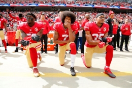 Pemain San Francisco 49ers (American Football) Colin Kaepernick (tengah) berlutut selama lagu kebangsaan. | Credit: EPA via thesun.co.uk
