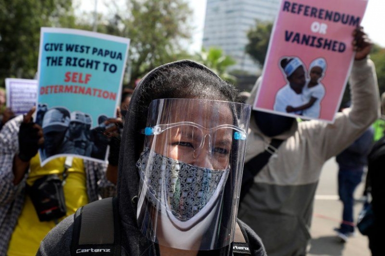 Seorang pendukung pro-kemerdekaan Papua memakai pelindung wajah selama demonstrasi memperingati 58 tahun Perjanjian New York di luar Kedutaan Besar AS di Jakarta pada 15 Agustus. Perjanjian, yang ditandatangani oleh Belanda dan Indonesia pada tahun 1962, menyebabkan Indonesia mengambil alih. Papua Barat dari penjajahan Belanda tahun 1963. Foto: Dita Alangkara --- AP