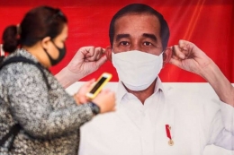 Pekerja yang menggunakan masker saat melintasi poster Presiden Joko Widodo yang menghimbau penggunaan masker di Stasiun Tanah Abang di Jakarta Pusat, Senin (14/9/2020). (PSBB Jakarta 14 September 2020 via kompas.com)