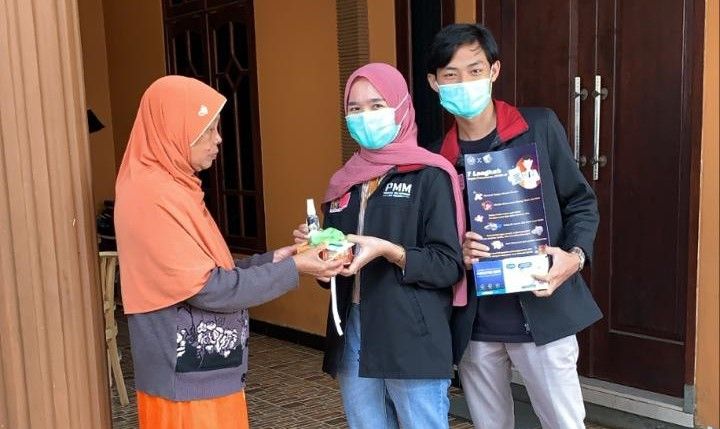 Mahasiswa UMM membagikan hansanitizer dan juga masker