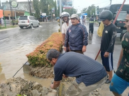 Toke Suum mengambil langkah mengurangi debit air diruas jalan dengan memotong beram jalan ( dok : Aldi)