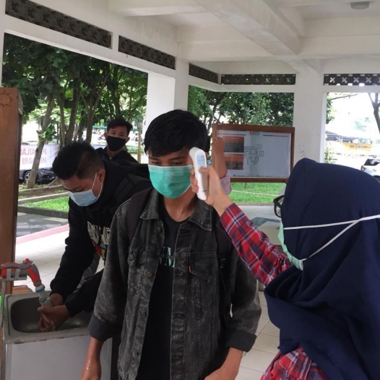 Gambar 1.2 melakukan cek suhu tubuh setiap ingin memasuki wilayah Gedung f4 (dokpri)
