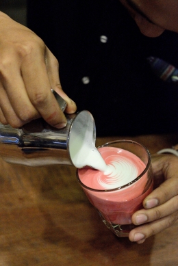 Barista Dongeng Kopi menuang susu pada pesanan beludru dadu panas