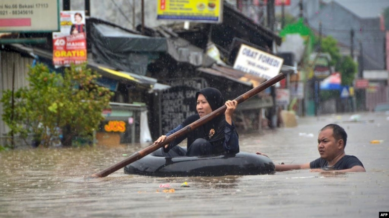  Mengarungi Banjir Menggunakan Rakit Ban | AFP 