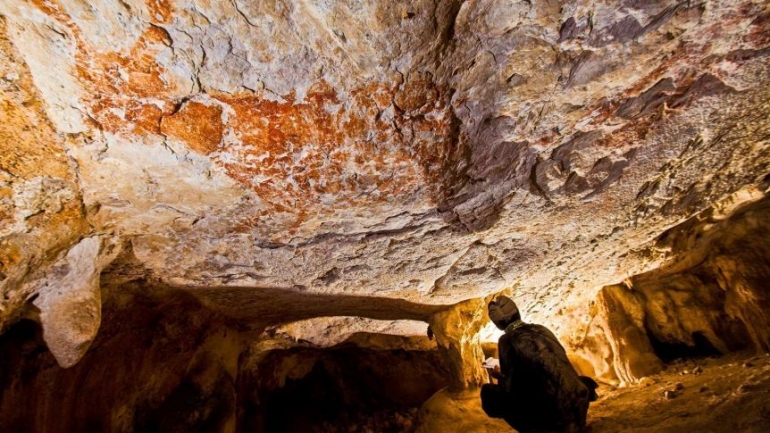 Lukisan gua dengan omjek banteng ini berusia 40.000 tahun ditemukan di gua di Kalimantan Timur. Photo: Pindi Setiawan)