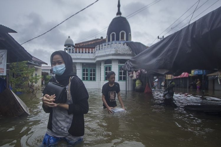 ilustrasi: Warga melintasi banjir yang menggenangi kawasan padat penduduk di Kabupaten Banjar, Kalimantan Selatan, Jumat (15/1/2021). (ANTARA FOTO/BAYU PRATAMA S via kompas.com)