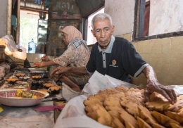 Basis dan Gidah sedang sibuk memasak roti kembang waru | MyMagz.net