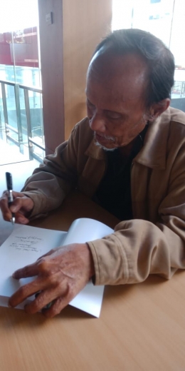 Bambang In Mardiono saat menandatangani bukunya. Foto dok/member grup Muara Baca