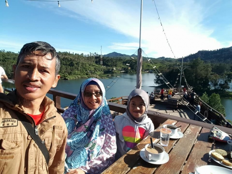 Kebun teh di sekeliling Situ Patenggang. Tampak tenda glamping dan restoran berbentuk perahu di kejauhan. | dokpri