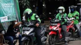 Petugas saat melakukan pengecekan suhu tubuh driver Gojek di Posko Aman J3K kawasan Pulomas, Jakarta Timur, Selasa (11/8/2020). Tribunnews/JEPRIMA.