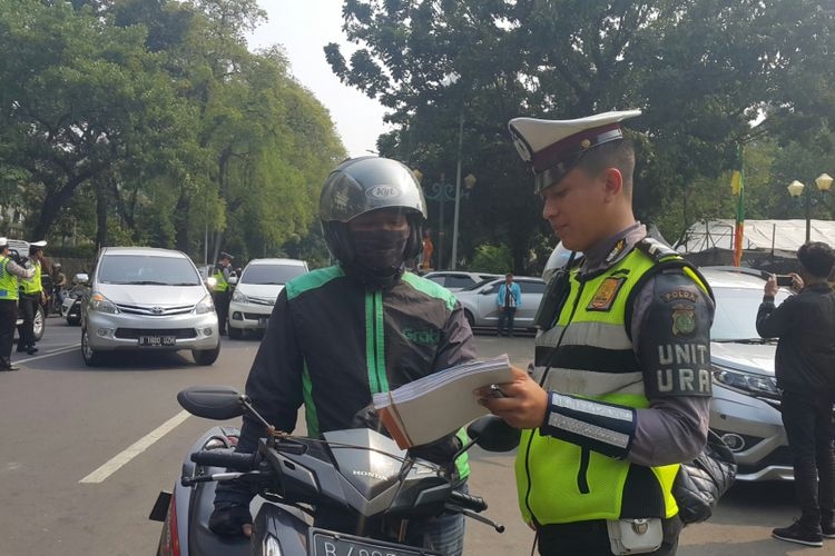 ilustrasi Polisi menilang pengendara sepeda motor yang belum membayar pajak kendaraan bermotor (PKB)-nya di Jalan Lapangan Banteng Selatan, Jakarta Pusat, Jumat (11/8/2017). (sumber: KOMPAS.com/NURSITA SARI) 