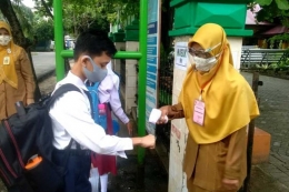 Pengecekan suhu tubuh terhadap siswa sekolah yang menerapkan pembelajaran tatap muka di masa pandemi Covid-19 di Kota Pekanbaru (Kompas.com)