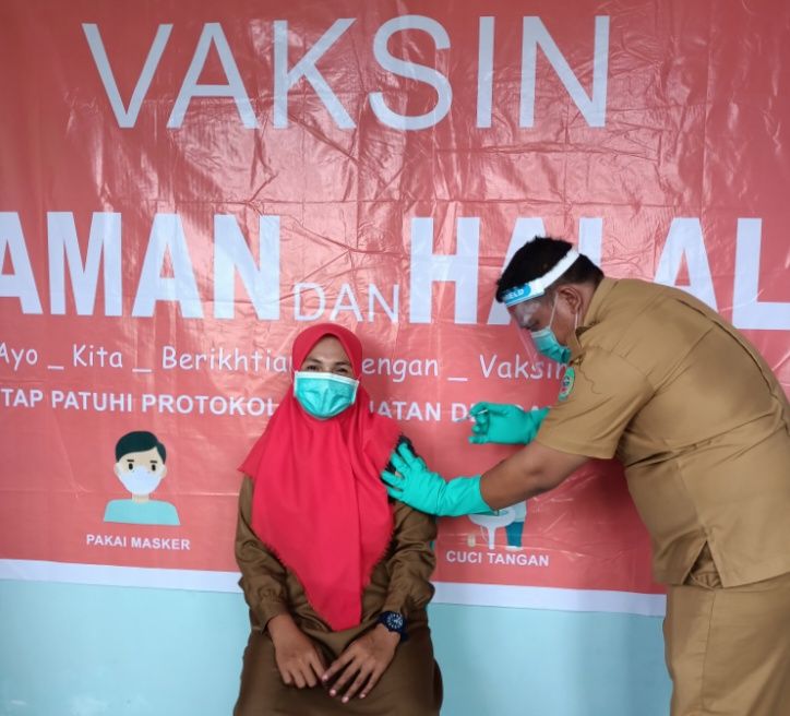 Foto : Tampak ibu kepala puskesmas Patlean rileks menerima suntikan vaksin pertama (dokpri).