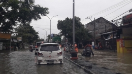 Banyak sepeda motor yang dituntun karena mogok terkena banjir. Mereka terjebak banjir ketika pulang kerja menuju rumah. | Foto: Wahyu Sapta.