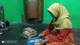 Putri sulungnya yang akan menikah bulan ini membantu mengemas kripik | Foto: Siti Nazarotin