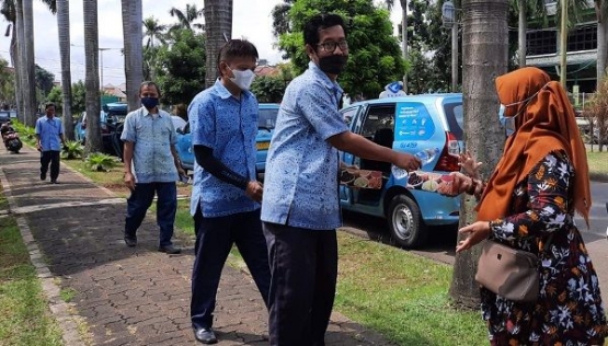 Pemred Sudut Pandang, Umi Sjarifah, membagikan nasi kotak kepada sopir taksi di Bekasi, Jumat (12/2/2021)/Foto:istimewa