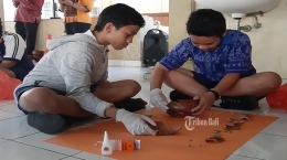  Dua siswa sedang belajar cara merekonstruksi gerabah (Foto: bali.tribunnews.com)