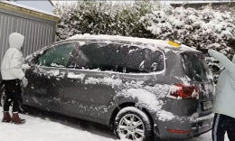 Membebaskan mobil dari tutupan salju sebelum dipakai. (Foto: Erwin Silaban)