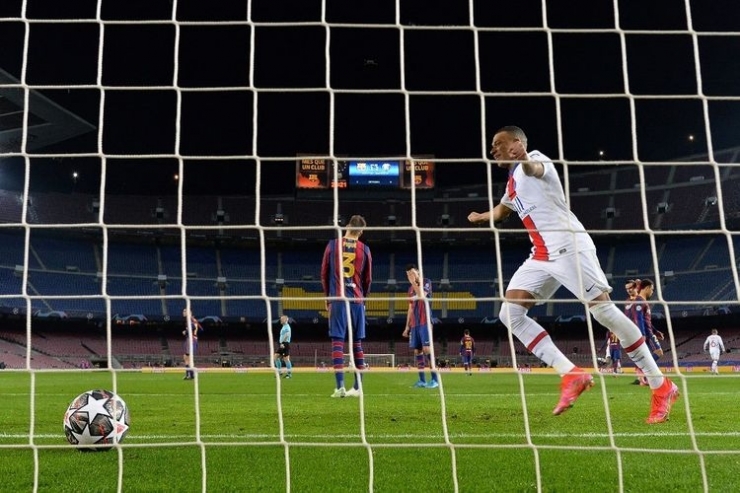 Penyerang Paris Saint-Germain Kylian Mbappe berselebrasi usai membobol gawang Barcelona pada laga leg pertama babak 16 besar Liga Champions 2020-2021 di Stadion Camp Nou, 16 Februari 2021. (Foto: AFP/LLUIS GENE via kompas.com)