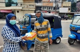 Pemred Sudut Pandang, Umi Sjarifah, membagikan nasi kotak dan masker kepada sopir bajaj di bilangan Petojo, Jakarta Pusat, Jumat (19/2/2021)/Foto:istimewa